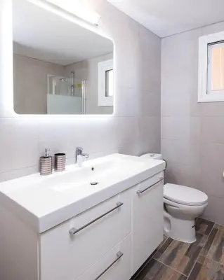 a white bathroom with a sink and a toilet at Happy Stay Apartment - Halefka Court in Larnaka