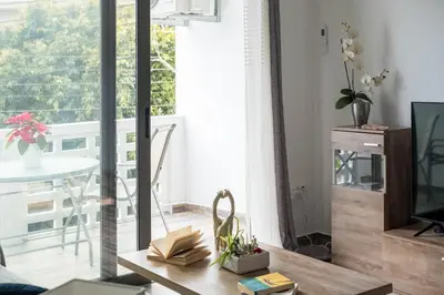 a living room with a table and a balcony at Happy Stay Apartment - Halefka Court in Larnaka