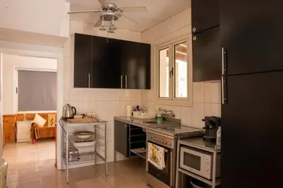 a kitchen with black cabinets and a stove at Spyros No23 Charming Oceanview Maisonette in Meneou