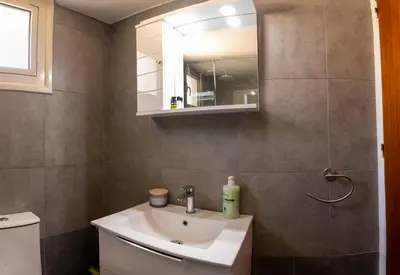 a bathroom with a sink and a mirror at Spyros No23 Charming Oceanview Maisonette in Meneou