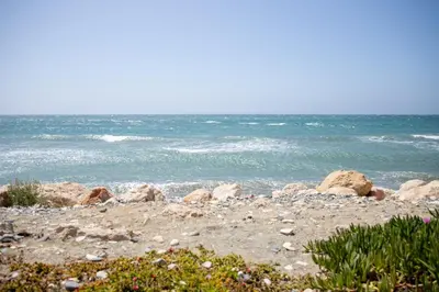 a rocky beach with the ocean in the background at Spyros No23 Charming Oceanview Maisonette in Meneou