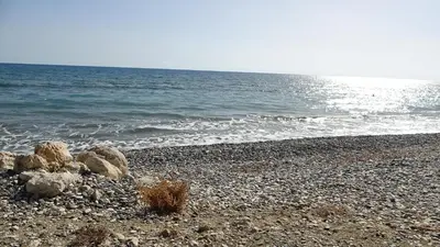 a rocky beach with the ocean in the background at Spyros No23 Charming Oceanview Maisonette in Meneou