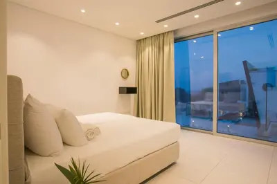 a bedroom with a bed and a large window at Cove Seaview Villas - Nautica in Ayia Napa