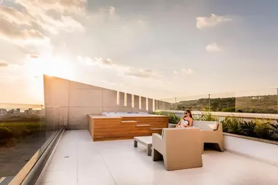 a woman sitting on the balcony of a building at Cove Seaview Villas - Nautica in Ayia Napa