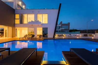a house with a swimming pool at night at Cove Seaview Villas - Neptune in Ayia Napa