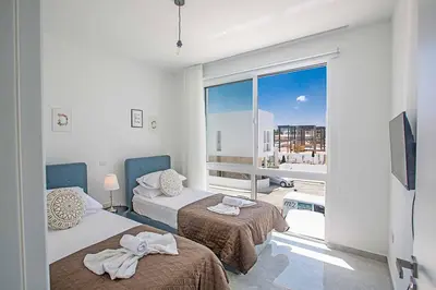 a bedroom with two beds and a large window at Vie Blue 4 in Protaras