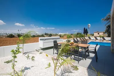 a patio with a table and chairs next to a pool at Vie Blue 4 in Protaras