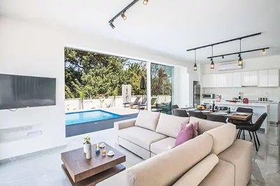a living room with a couch and a tv and a kitchen at Vie Blue 4 in Protaras