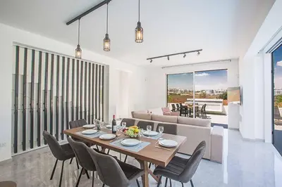 a dining room and living room with a table and chairs at Vie Blue 4 in Protaras