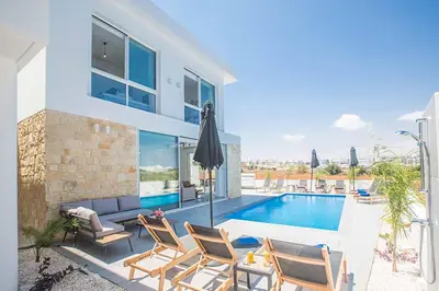 a villa with a swimming pool and some chairs at Vie Blue 4 in Protaras