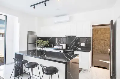a kitchen with black and white counters and stools at Vie Bleu 1 in Protaras