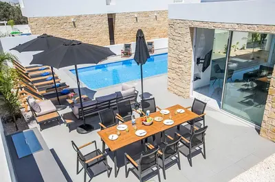 a patio with a table and chairs and a pool at Vie Bleu 1 in Protaras