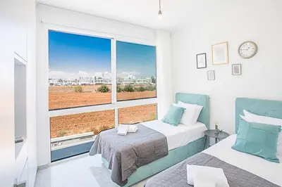 a bedroom with two beds and a large window at Vie Bleu 3 in Protaras