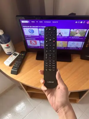 a person holding a remote control in front of a computer monitor at Avra House in Limassol