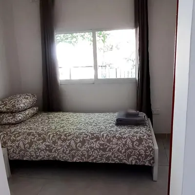 a small bedroom with a bed and a window at Avra House in Limassol