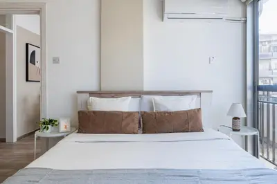 a bedroom with a large bed with white sheets and pillows at Berries 1-BR Apt in Larnaca in Larnaka