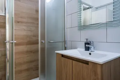 a bathroom with a sink and a mirror and a shower at Berries 1-BR Apt in Larnaca in Larnaka
