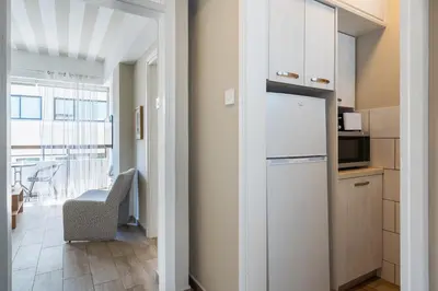 a kitchen with a white refrigerator and a table at Berries 1-BR Apt in Larnaca in Larnaka