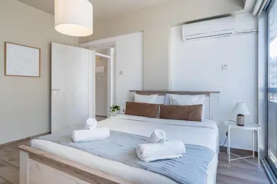 a bedroom with a large bed with towels on it at Berries 1-BR Apt in Larnaca in Larnaka