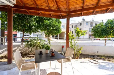a patio with a table and chairs under a wooden pergola at Azure 2-BR W/Terrace in Larnaca in Larnaka