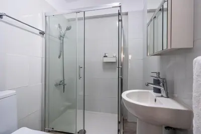a bathroom with a glass shower and a sink at Azure 2-BR W/Terrace in Larnaca in Larnaka
