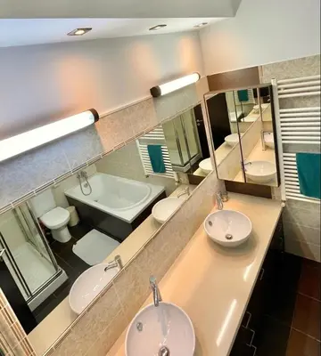 a bathroom with two sinks and a tub and a mirror at El Soleo Luxury Villa in Limassol