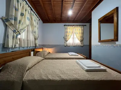 a bedroom with two beds and a window at Kapilio Cottage House in Kapilio