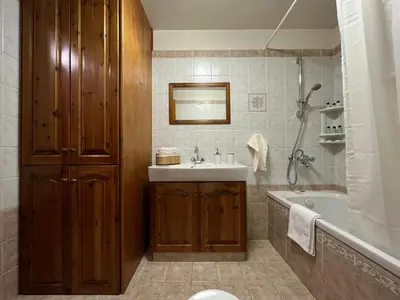a bathroom with a sink and a tub and a toilet at Kapilio Cottage House in Kapilio