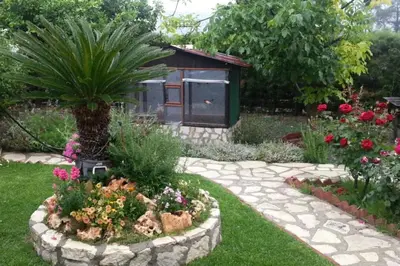 a garden with a garden path with flowers and a bird house at Kapilio Cottage House in Kapilio