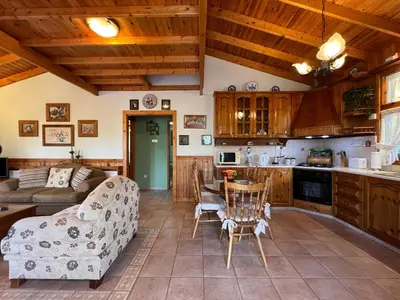 a kitchen and living room with a couch and a table at Kapilio Cottage House in Kapilio