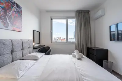 a bedroom with a large white bed with a window at Sunflower 1-Bedroom Apartment in Larnaca in Larnaka