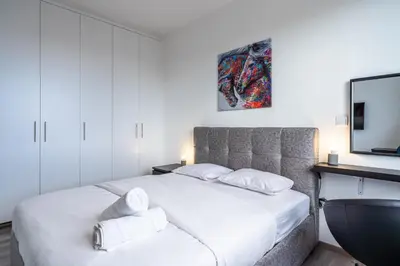 a bedroom with a white bed and a tv at Sunflower 1-Bedroom Apartment in Larnaca in Larnaka