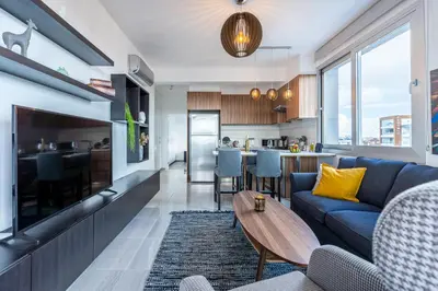 a living room with a blue couch and a table at Sunflower 1-Bedroom Apartment in Larnaca in Larnaka