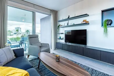 a living room with a tv and a couch and a table at Sunflower 1-Bedroom Apartment in Larnaca in Larnaka