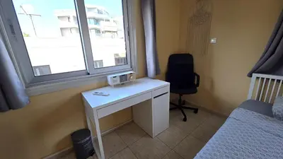 a room with a desk and a bed and a window at Comfy and Exquisite ROOMS in a Shared 3BR Apartment Near Main Harbor, City Center in Larnaka