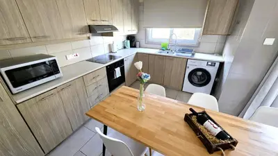 a kitchen with a wooden table with a vase of flowers on it at Comfy and Exquisite ROOMS in a Shared 3BR Apartment Near Main Harbor, City Center in Larnaka