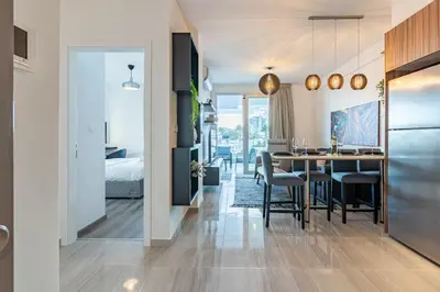 a kitchen and dining room with a table and chairs at Sunshine 1-Bedroom Apartment in Larnaca in Larnaka