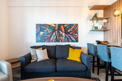 a living room with a blue couch and yellow pillows at Sunshine 1-Bedroom Apartment in Larnaca in Larnaka