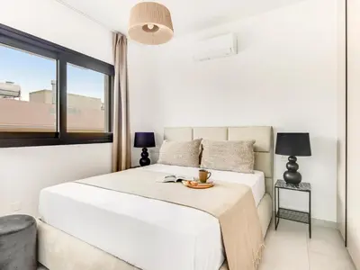 a white bedroom with a bed and a window at Sanders Only in Limassol