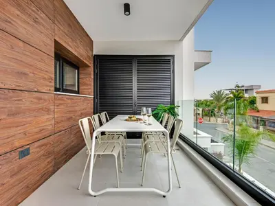 a dining room with a table and chairs on a balcony at Sanders Only in Limassol