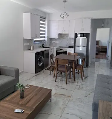 a kitchen and living room with a table and chairs at ICEBUILD APARTMENTS in Nicosia