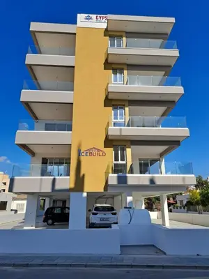 a yellow building with a car parked in front of it at ICEBUILD APARTMENTS in Nicosia