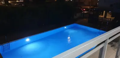 a blue swimming pool at night with lights at LINA'S HOME & POOL - Breakbooking CY in Laxia