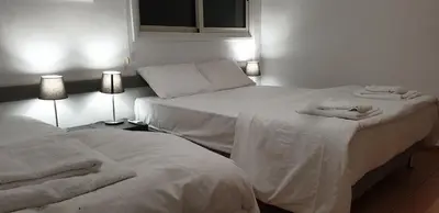 two beds in a room with white sheets and towels at LINA'S HOME & POOL - Breakbooking CY in Laxia