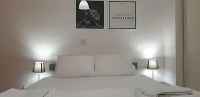 a bedroom with a white bed with two lamps at LINA'S HOME & POOL - Breakbooking CY in Laxia