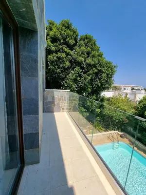 a balcony with a swimming pool next to a house at Mosaic villa by the sea in Protaras