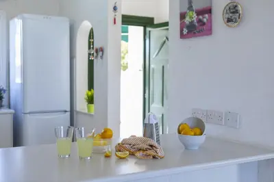 a kitchen counter with glasses of orange juice and fruit on it at Melis Villa - Charming villa in Central Protaras in Protaras