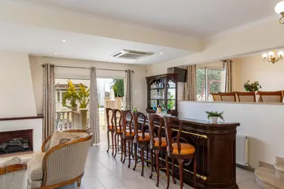 a dining room with a bar with chairs at Protaras Posidon By The Sea in Protaras