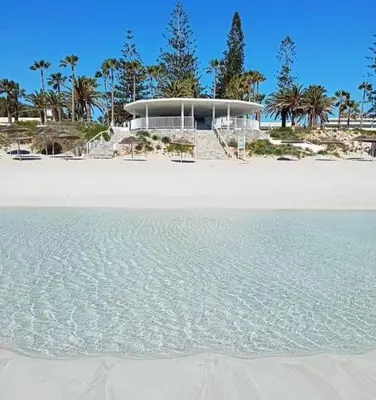 a building on the beach with the water at NISSI GOLDEN SANDS SEA VIEW 2 BEDROOM Apartment in Ayia Napa