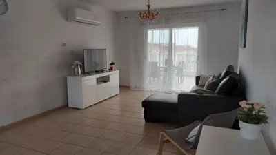 a living room with a couch and a tv at NISSI GOLDEN SANDS SEA VIEW 2 BEDROOM Apartment in Ayia Napa